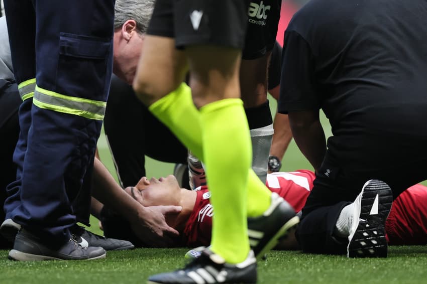 Gabriel Brazão deixa o gramado da Arena MRV de ambulância. (Foto: Gilson Lobo/AGIF)