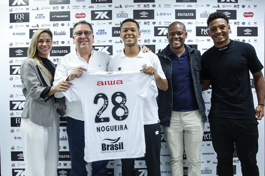 David Nogueira assina o primeiro contrato profissional ao lado da família e do presidente Marcelo Teixeira. (Foto: Reinaldo Campos/Santos FC)