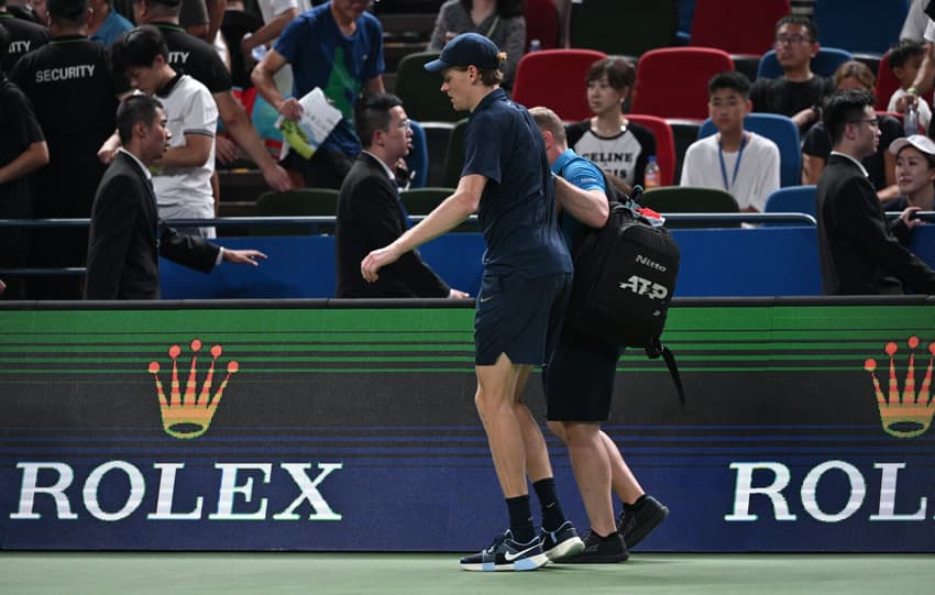 O italiano Jannik Sinner recebe ajuda para deixar a quadra durante sua partida contra o holandês Tallon Griekspoor no Masters 1000 de Shanghai (Foto: Hector Retamal / AFP)
