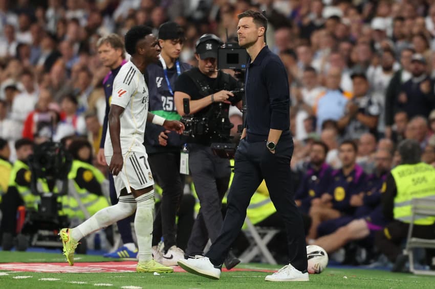 Vini Jr passa ao lado de Xabi Alonso ao ser substituído no El Clásico (Foto: Oscar DEL POZO / AFP)