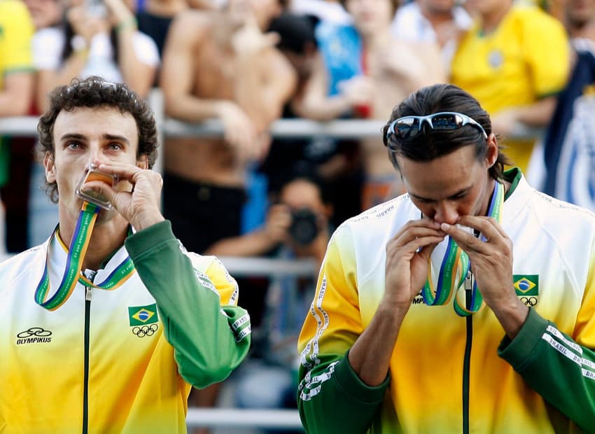 Emanuel Rego (L) of Brazil and mate Ricardo Santos kiss their medals after winning the gold medal against the U.S. in the men's beach volleyball competition at the Pan American Games in Rio de Janeiro July 22, 2007. REUTERS/Daniel Munoz (BRAZIL)