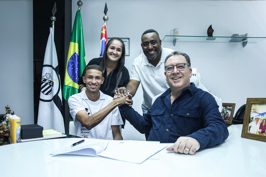 Vinicius Lira assina renovação com o Santos ao lado de familiares e do presidente Marcelo Teixeira. (Foto: Reinaldo Campos/Santos FC)