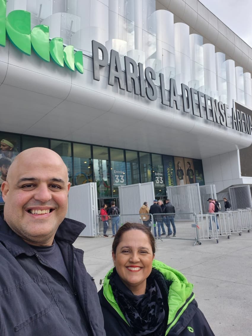 Casal Rodrigo Sullivan e Angélica em frente à arena onde ocorreu a partida de João Fonseca em Paris.