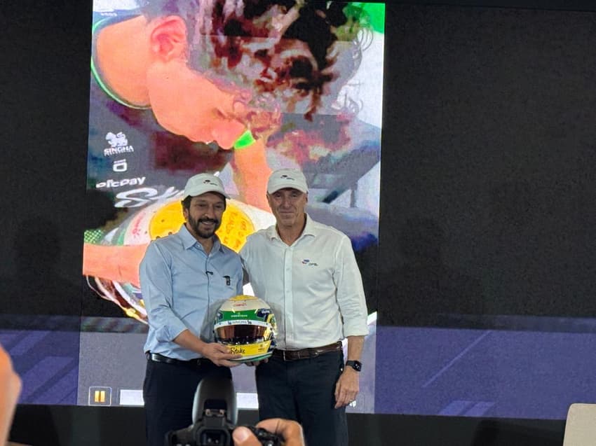 Ricardo Nunes recebe capacete autografado por Gabriel Bortoleto durante coletiva da Fórmula 1 (Foto: Isabella Zuppo)