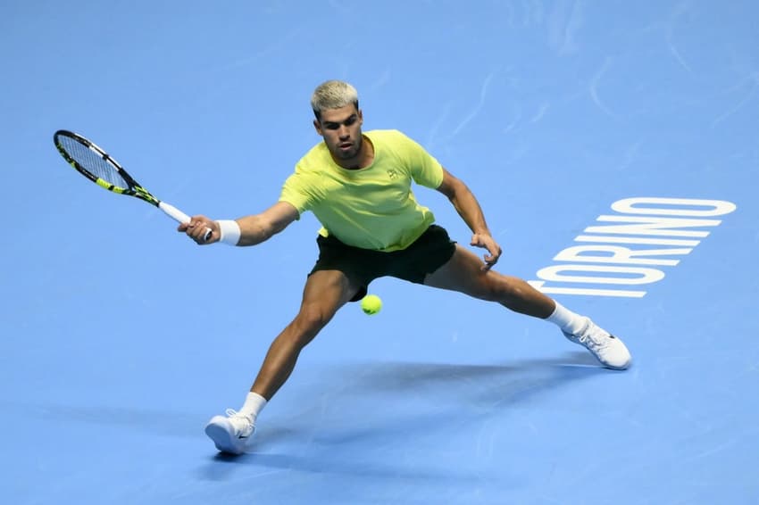 O espanhol Carlos Alcaraz devolve a bola na vitória sobre o australiano Alex De Minaur (Foto: Marco BERTORELLO / AFP)