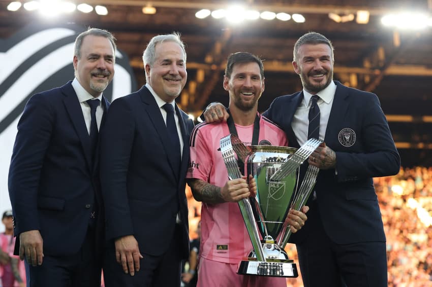 Lionel Messi com o troféu da MLS em mãos ao lado de Beckham e outros dois dirigentes