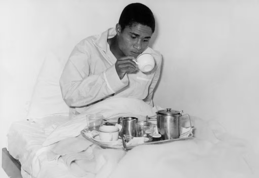 Eusébio bebe xícara deitado em uma cama