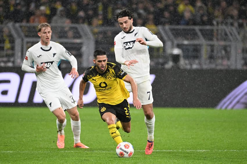 Yan Couto, do Borussia Dortmund, Max Moerstedt e Leon Avdullahu, ambos do Hoffenheim, disputam a bola na partida válida pela Bundesliga 2025/26 (Foto: Uwe Kraft/AFP)