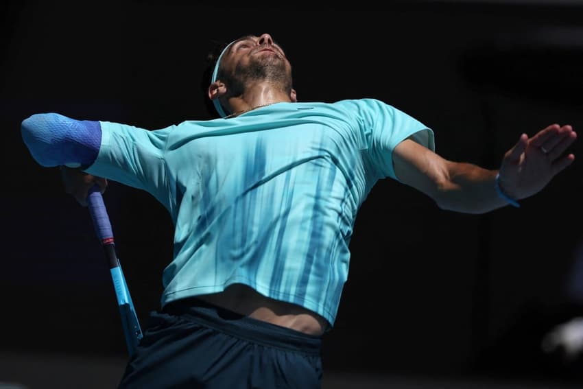 O italiano Lorenzo Musetti saca na vitória sobre o compatriota Lorenzo Sonego no Australian Open (Foto: Martin KEEP / AFP)