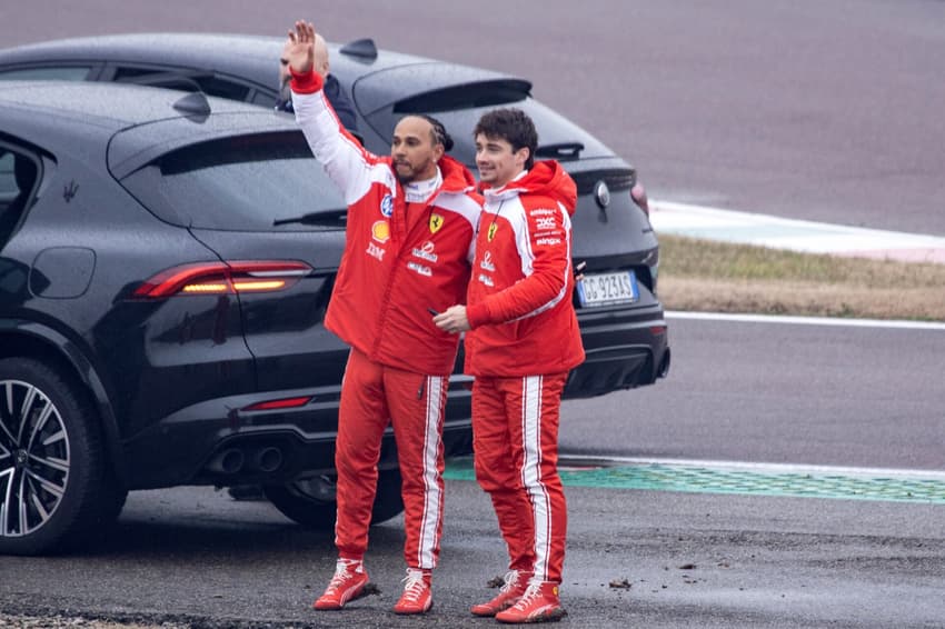 Lewis Hamilton e Charles Leclerc acenam para fãs após testarem a nova Ferrari SF-26 em Fiorano, em 23 de janeiro de 2026 (Foto: Federico Scoppa/AFP)