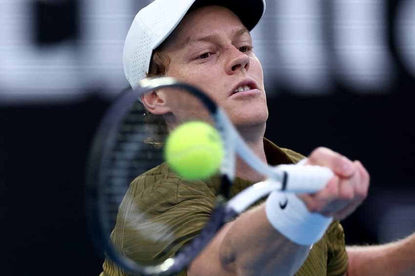 O italiano Jannik Sinner acelera a bola na partida contra o americano Ben Shelton no Australian Open (Foto: IZHAR KHAN / AFP)