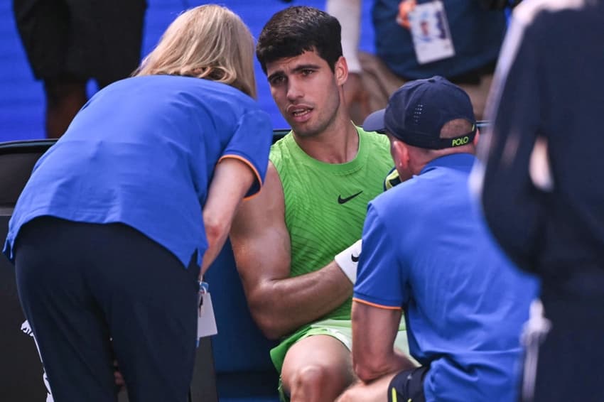 O espanhol Carlos Alcaraz recebe atendimento médico na semifinal do Australian Open contra o alemão Alexander Zverev (Foto: WILLIAM WEST / AFP)