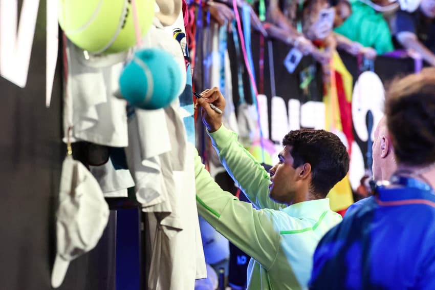 O espanhol Carlos Alcaraz dá autógrafos após vencer o alemão Alexander Zverev na semifinal masculina do Australian Open, em Melbourne, em 30 de janeiro de 2026. (Foto: Izhar Khan/Afp)
