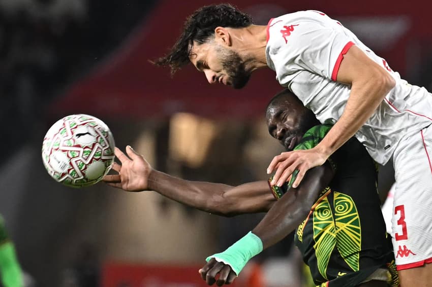 Ellyes Skhiri (acima) disputa a bola com Montassar Talbi (abaixo) durante a partida entre Mali e Tunísia pelas oitavas de final da Copa Africana de Nações (Foto: Paul Ellis/AFP)
