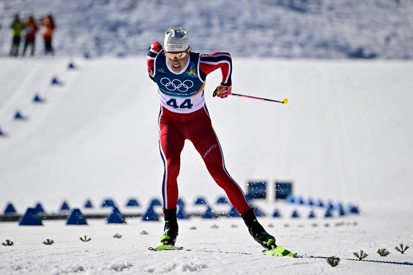 O norueguês Johannes Høsflot Klæbo cruza a linha de chegada nos 10km livre com largada intervalada do esqui cross-country, no Estádio de Tesero, nos Jogos Olímpicos de Inverno Milano Cortina 2026, em 13 de fevereiro de 2026. (Foto: Tobias Schwarz/AFP)