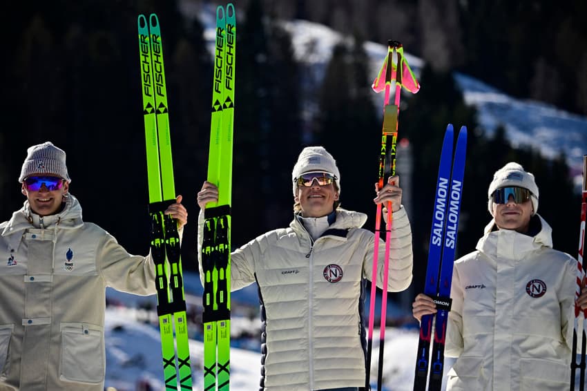 Da esquerda: Mathis Desloges (França), Johannes Høsflot Klæbo (Noruega) e Einar Hedegart (Noruega) comemoram no pódio dos 10km livre do esqui cross-country, nos Jogos Olímpicos de Inverno Milano Cortina 2026, em Tesero, em 13 de fevereiro de 2026. (Foto: Tobias Schwarz/AFP)