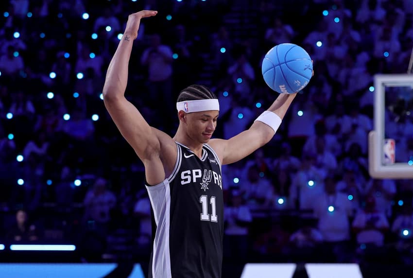 Carter Bryant, camisa 11 do San Antonio Spurs, anima a torcida antes de sua enterrada durante o Concurso de Enterradas da AT&T no All-Star Weekend da NBA de 2026 (Foto: Ryan Sirius Sun/Getty Images/AFP)