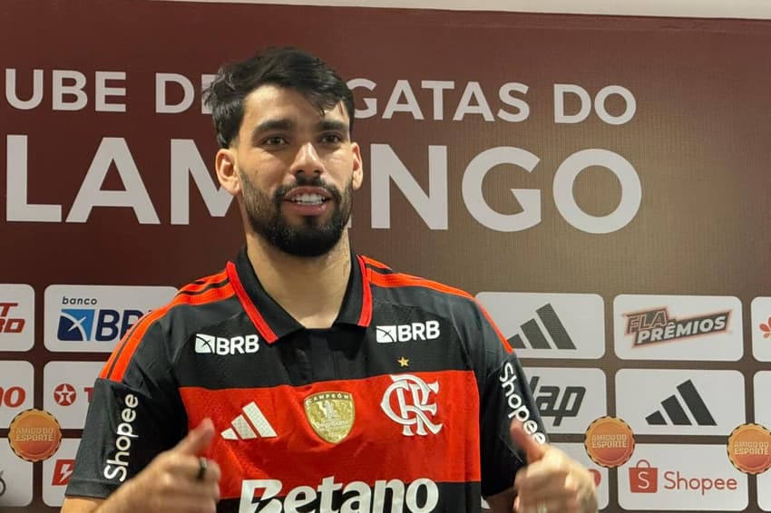 Lucas Paquetá sorri ao vestir camisa do Flamengo em sua apresentação no clube (Foto: Pedro Werneck / Lance!)