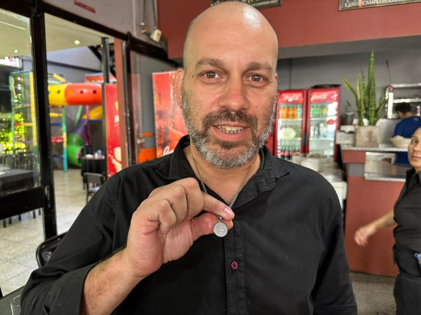 Dono do restaurante da sede do Lanús exibe seu colar com o escudo do time (Foto: Lucas Bayer/Lance!)