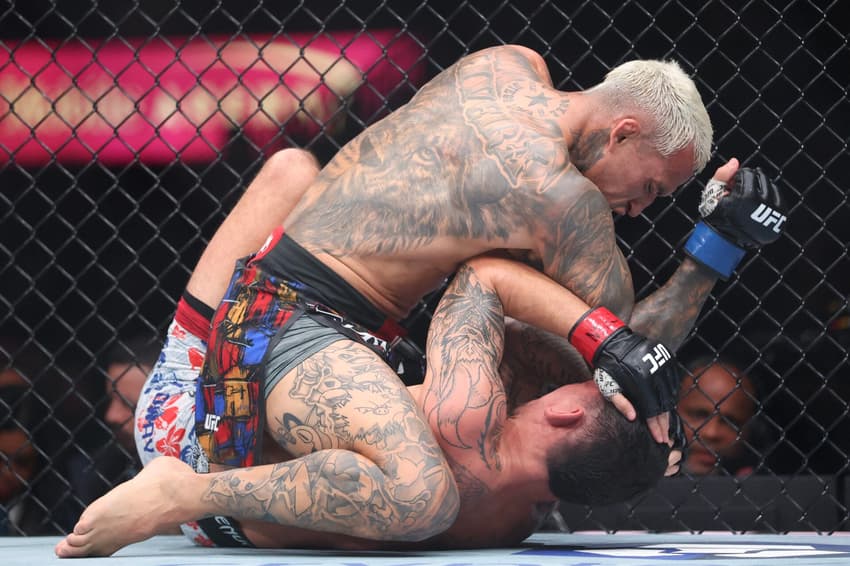 Charles "Do Bronx" Oliveira golpeia Max Holloway durante a luta pelo cinturão BMF no T-Mobile Arena. (Foto: Sean M. Haffey/Getty Images/AFP)