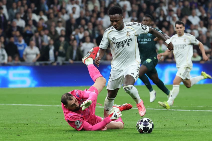 Vini Jr. sofre falta do goleiro italiano do Manchester City, número 25, Gianluigi Donnarumma, resultando em pênalti durante a partida de ida das oitavas de final da Champions League entre Real Madrid e Manchester City, no Estádio Santiago Bernabéu (Foto: Thomas Coex / AFP)
