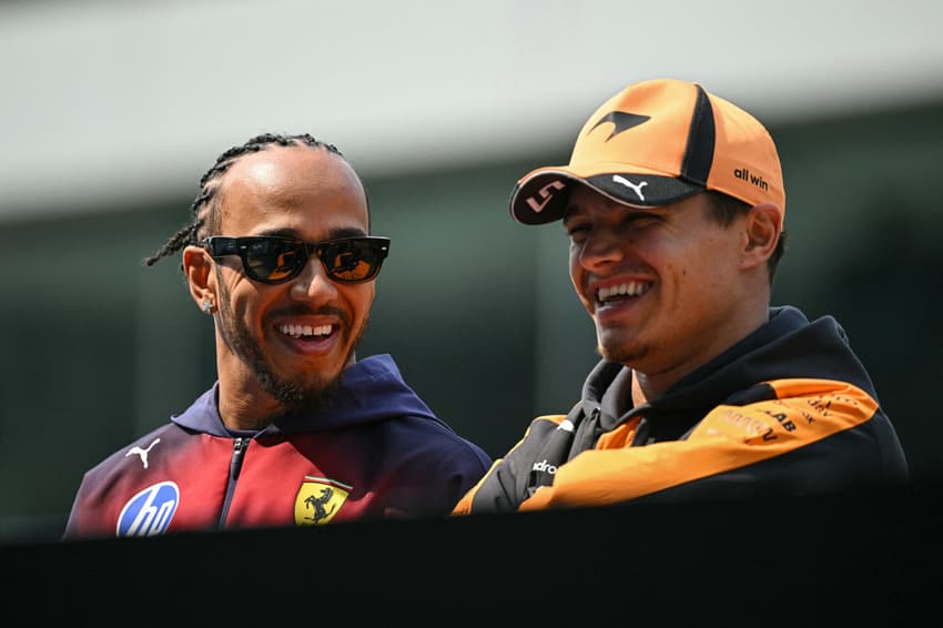 Lewis Hamilton e Lando Norris conversam durante o desfile dos pilotos antes do GP da China de Fórmula 1, em 15 de março de 2026. (Foto: Greg Baker/AFP)