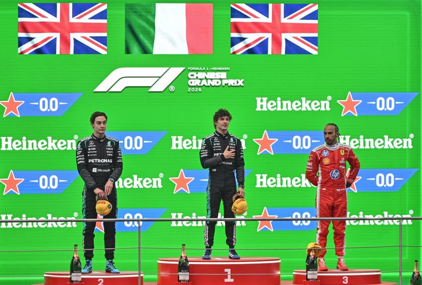 Kimi Antonelli, George Russell e Lewis Hamilton comemoram no pódio após o GP da China de Fórmula 1, em Xangai (Foto: Hector Retamal/AFP)