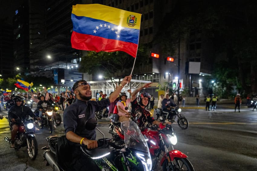 Torcedor venezuelano celebra com a bandeira após a vitória sobre os Estados Unidos na final do Clássico Mundial de Beisebol de 2026, em Caracas, em 17 de março de 2026, marcando o título inédito do país. (Foto: Juan Barreto/afp)