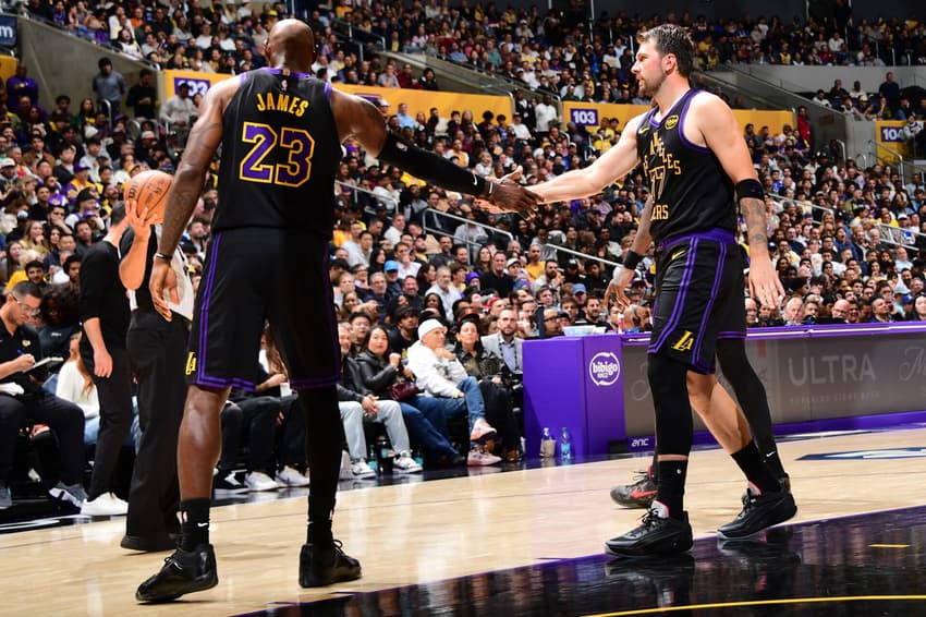 LeBron James (esquerda) e Luka Doncic (direita) se cumprimentam durante a partida do Lakers contra o Cleveland Cavaliers (Foto: Adam Pantozzi/ Getty Images via AFP)