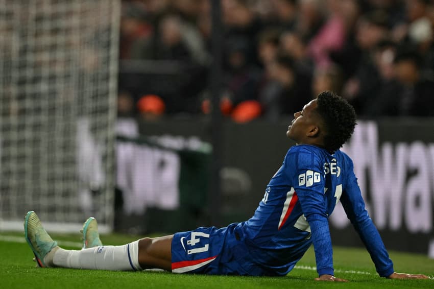 Estêvão caído no gramado após sentir lesão muscular na derrota do Chelsea para o Manchester United, na Premier League