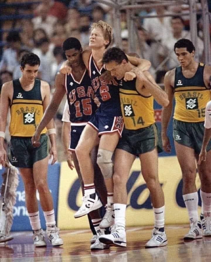 Steve Kerr, técnico do Golden State Warriors, sendo carregado por Oscar Schmidt e Seleção Brasileira quando rompeu seu LCA em mundial de basquete (Foto: Reprodução/X)