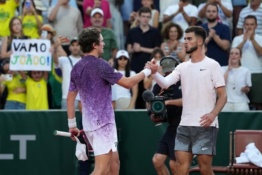 João Fonseca é cumprimentado pelo croata Dino Prizmic após a vitória épica em Roland Garros (Foto: Dimitar DILKOFF / AFP)