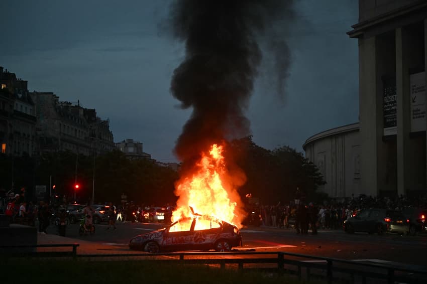 Um carro é incendiado enquanto torcedores do PSG comemoram a vitória de sua equipe na final da Champions League entre o Paris Saint-Germain (PSG) e o Arsenal FC, disputada em Budapeste, na Place du Trocadéro, em Paris (Foto: Lou Benoist / AFP)