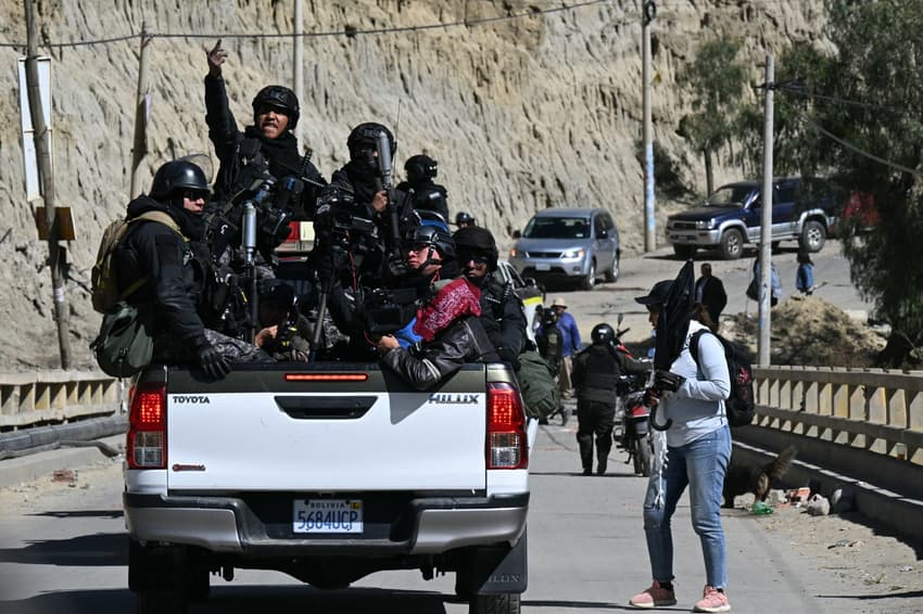 Policiais de choque viajam na traseira de uma caminhonete durante confrontos com manifestantes rurais em Lipari, no departamento de La Paz, Bolívia, em 16 de maio de 2026.  O governo da Bolívia chegou a um acordo em 15 de maio com milhares de mineiros que entraram em confronto com a polícia em um protesto que paralisou o centro de La Paz. No entanto, outros setores continuam bloqueando as vias de acesso à cidade, sede do Poder Executivo e do Congresso.