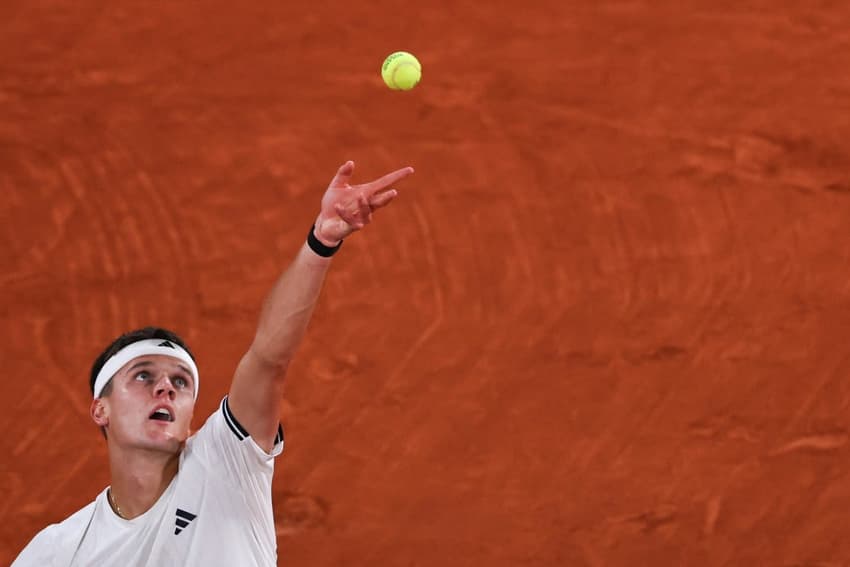 O tcheco Jakub Mensik saca na partida cotnra João Fonseca em Roland Garros (Foto: Anne-Christine POUJOULAT / AFP)