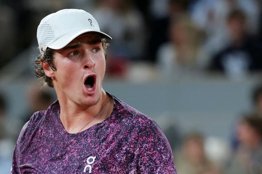 O brasileiro João Fonseca reage após um ponto em partida contra o tcheco Jakub Mensik pelas quartas de final de simples masculina no décimo dia do torneio de tênis de Roland Garros, na quadra Philippe-Chatrier, em Paris (Foto: Thomas Samson / Afp)