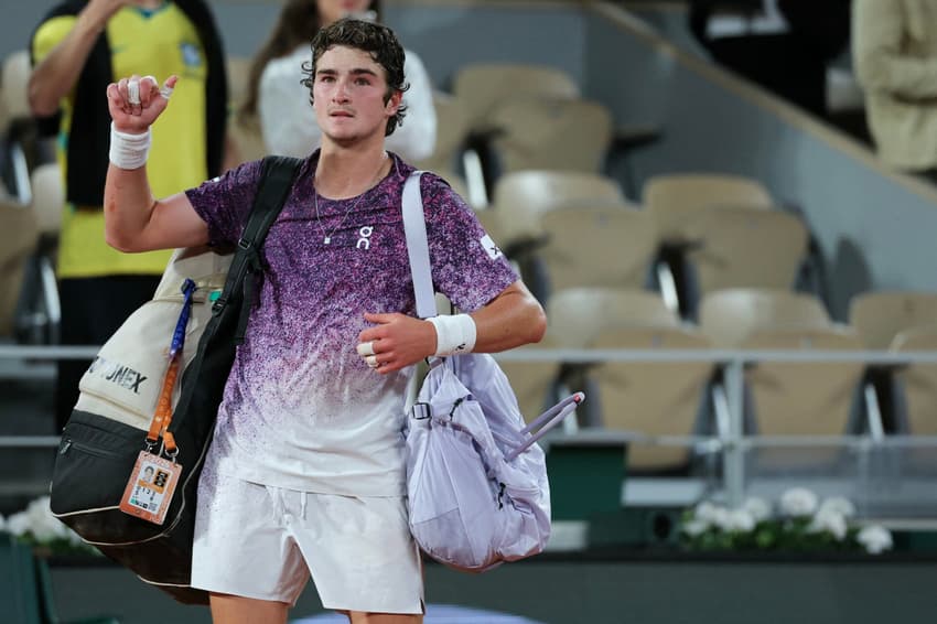 O brasileiro João Fonseca deixa a quadra após perder para o tcheco Jakub Mensik ao final da partida de quartas de final de simples masculina no décimo dia do torneio de tênis de Roland Garros, na quadra Philippe-Chatrier, em Paris (Foto: Thomas Samson / Afp)