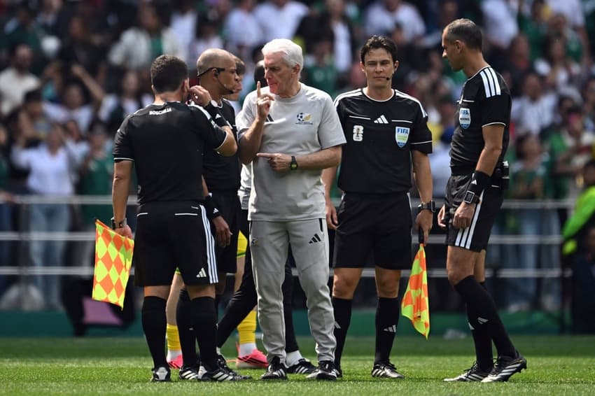 O técnico belga Hugo Broos, da seleção da África do Sul, gesticula com o árbitro brasileiro Wilton Pereira Sampaio (Foto: Yuri CORTEZ / AFP)