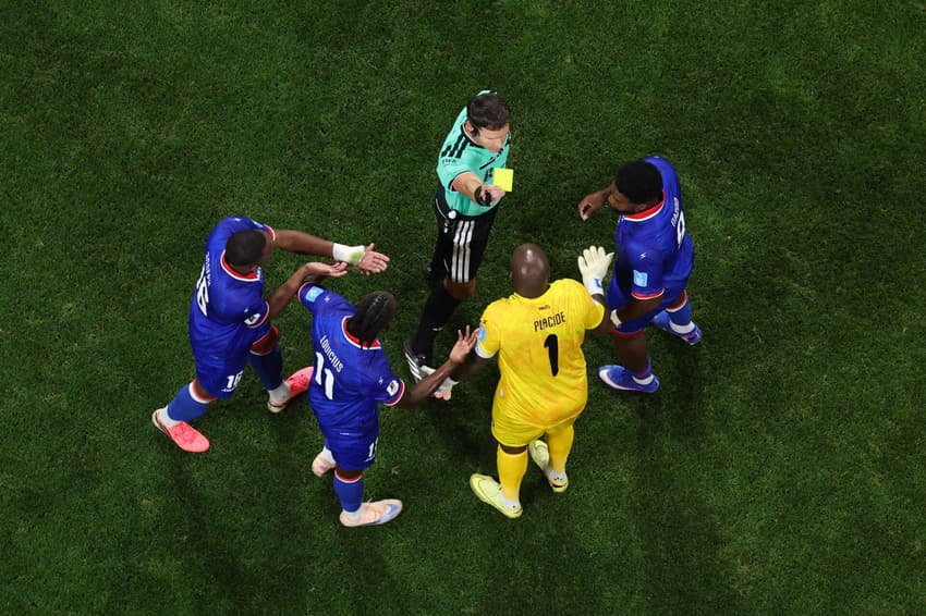 Jogadores do Haiti em volta do árbitro, reclamando pela aplicação do cartão amarelo durante a Copa do Mundo de 2026.