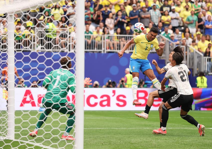 Casemiro salta e cabeceia diante do goleiro Suzuki para marcar o primeiro gol do Brasil na partida contra o Japão pela Copa do Mundo
