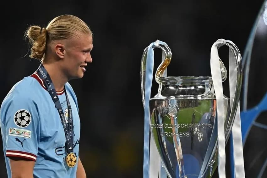 Haaland olha para o troféu da Champions Leaguea após vitória na final
