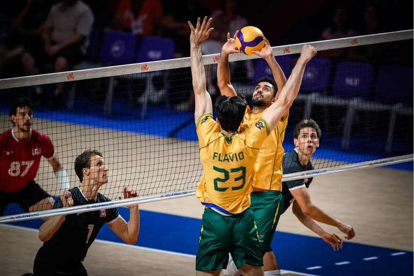 Fernando Cachopa realiza ação de levantamento e Flávio se movimenta para atacar em Brasil x Canadá pela Liga das Nações de Vôlei Masculino