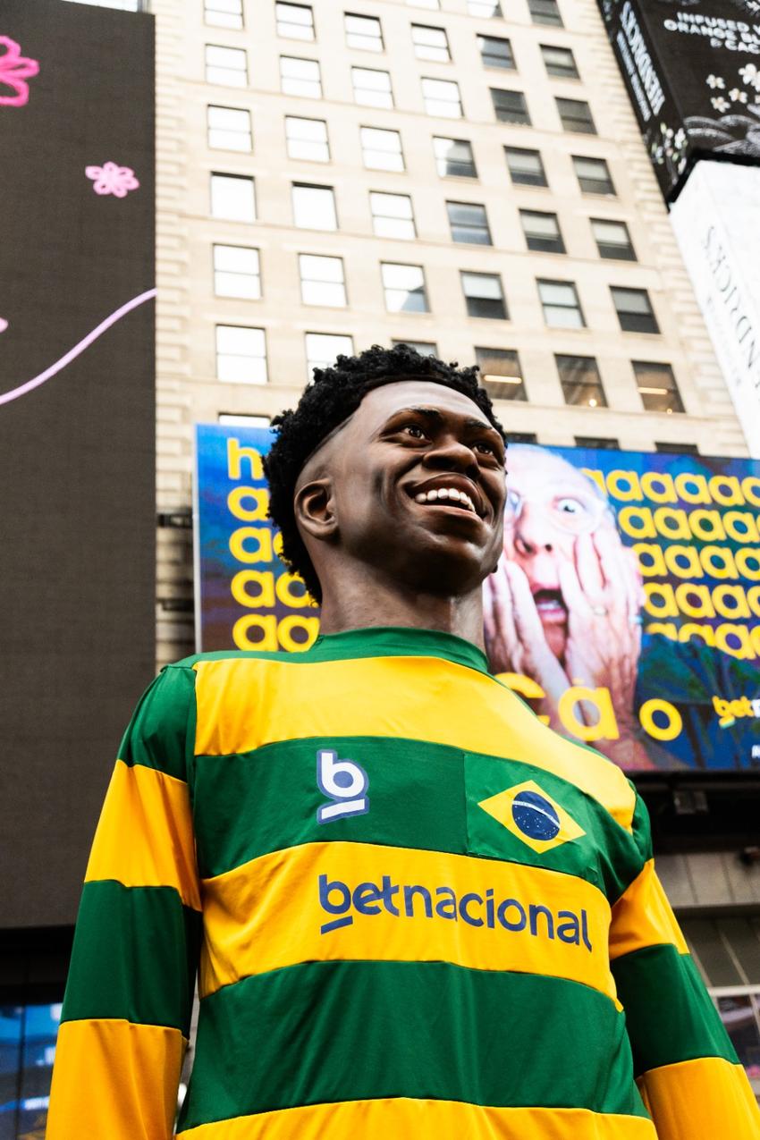 Vinicius Jr vestido com camisa verde e amarela 