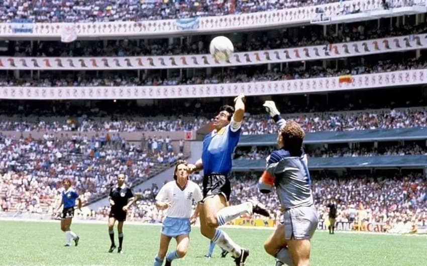 Maradona, da Argentina, sobe para disputar a bola com Peter Shilton, da Inglaterra, e marca gol de mão nas quartas de final da Copa do Mundo de 1986
