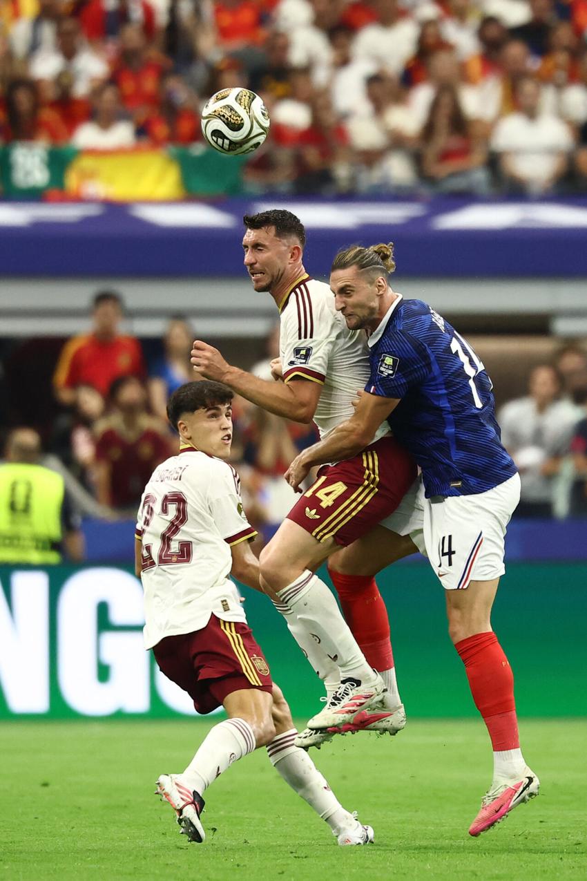 Pau Cubarsí e Aymeric Laporte, da Espanha, disputam a bola com o meio-campista francês Adrien Rabiot durante a semifinal entre França e Espanha.