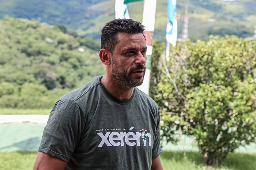 Anunciado como técnico do sub-20 do Fluminense, Fred olha para o lado de camisa cinza com a palavra "Xerém" e