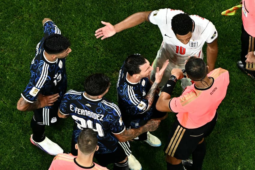 Jogadores discutindo com árbitro em campo