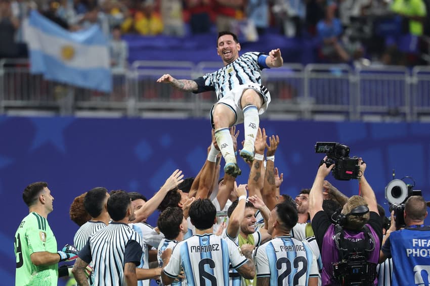 Messi sorridente é levantado por companheiros de time após vitória de virada da Argentina (Foto: Odd ANDERSEN / AFP)