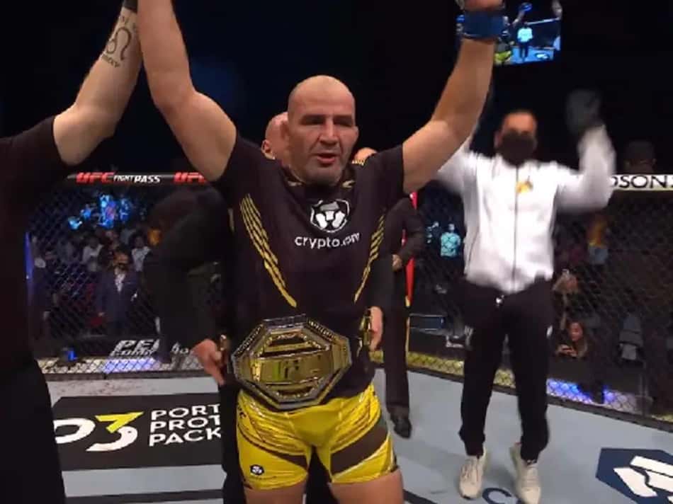 Glover Teixeira levanta os braços com o cinturão do UFC