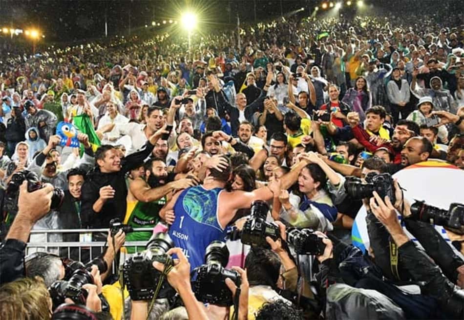 Bruno comemora com a torcida o ouro conquistado no vôlei de praia ao lado de Alison